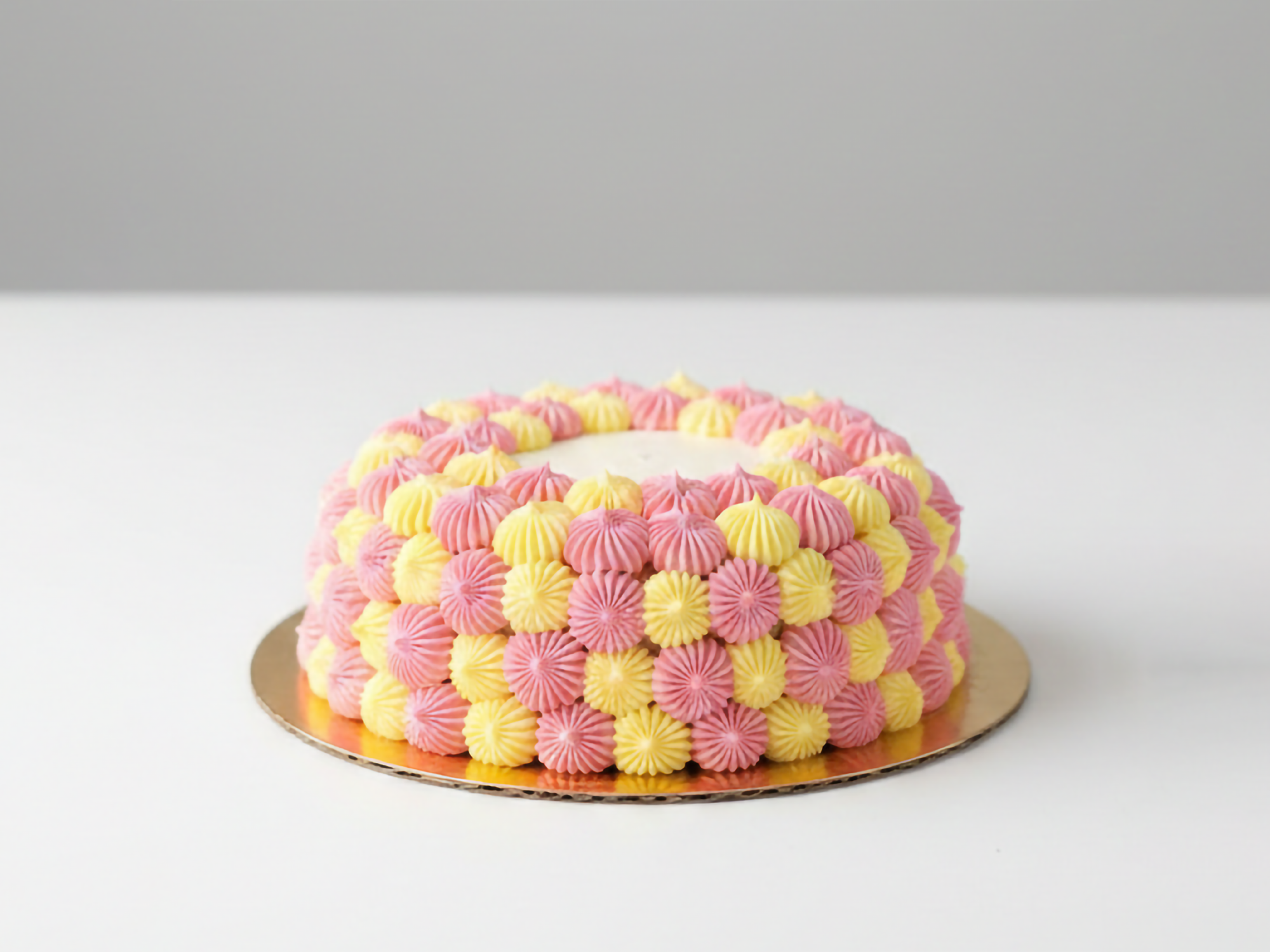 Ploetertaart met zachte biscuit en luchtige slagroom, afgewerkt in twee vrolijke kleuren